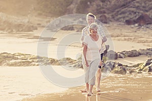 Lovely senior mature couple on their 60s or 70s retired walking happy and relaxed on beach sea shore in romantic aging together