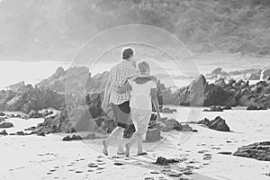 Lovely senior mature couple on their 60s or 70s retired walking happy and relaxed on beach sea shore in romantic aging together