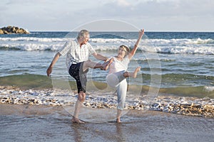 Lovely senior mature couple on their 60s or 70s retired walking happy and relaxed on beach sea shore in romantic aging together