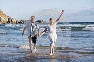 Lovely senior mature couple on their 60s or 70s retired walking happy and relaxed on beach sea shore in romantic aging together