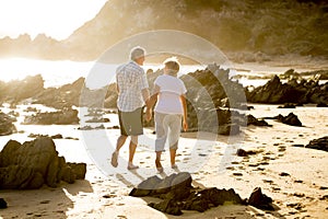 Lovely senior mature couple on their 60s or 70s retired walking happy and relaxed on beach sea shore in romantic aging together photo