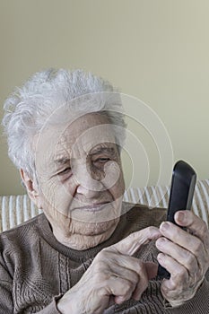 Senior woman dialling someone with a mobile phone photo