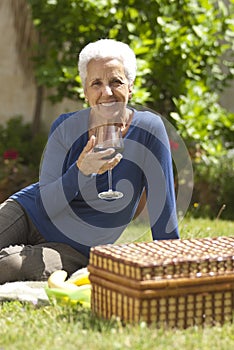 Lovely senior woman enjoying a glass of red wine