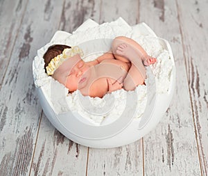 Lovely sleeping newborn girl in eggshell basket