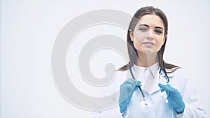 Lovely smiling female putting stethoscope over her neck, folding hands, looking confident.