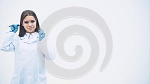 Lovely smiling female putting stethoscope over her neck, folding hands, looking self-confident.