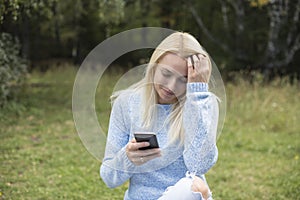 Lovely smiling girl reads sms on mobile phone,