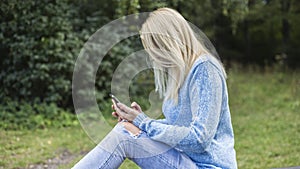 Lovely smiling girl reads sms on mobile phone,