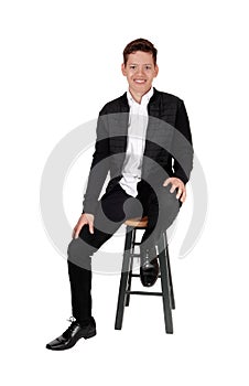 Lovely smiling teenager boy sitting on a chair