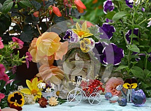 Lovely summer still life with tiny bicycle, doll house, flowers and berries in the garden