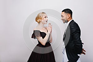 Lovely sweathearts of attractive astonished young woman in luxury evening dress and handsome man in tuxedo dating on