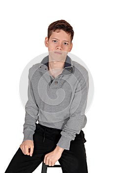 Lovely teenage boy sitting on a chair