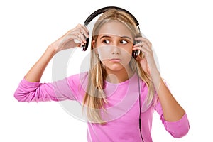 Lovely teenage girl removing her headphones for noise or loud music,isolated