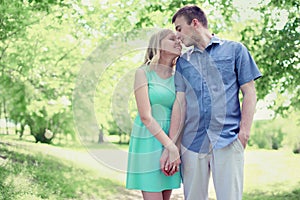 Lovely tender young couple in love walking in sunny spring park