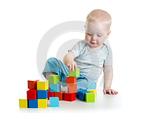 Lovely toddler baby playing with building cubes. Isolated on white.