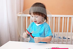 Lovely toddler boy with scissors