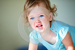 Lovely toddler girl with curly blonde hair indoors