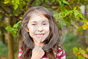 Portrait of girl pointing with finger her new adult tooth