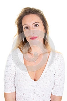 Lovely woman with blonde hair face looks at camera wears white casual clothes poses in studio background