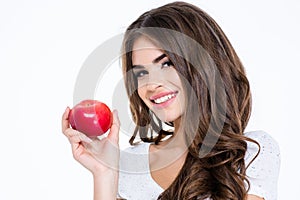 Lovely woman holding apple and looking at camera