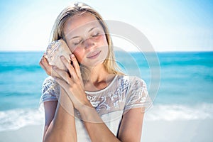 Lovely woman listening to a shell