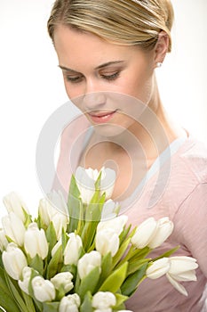 Lovely woman looking down white tulip flowers