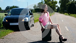 Lovely woman sitting on canister on country road