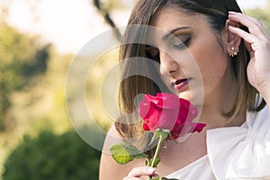 Lovely woman smelling a red rose