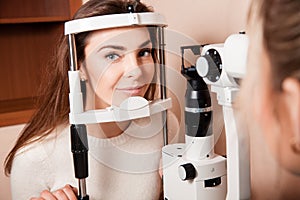 Lovely Young adult woman is having eye exam performed by eye doc