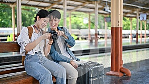 A lovely young Asian couple is waiting for their train at the railway station. Backpacker