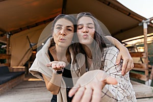 Lovely young caucasian lady sends air kisses to camera enjoying her time.