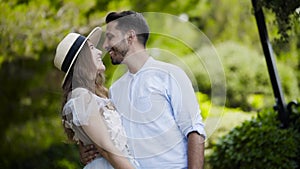 Lovely young couple admiring each other. Action. Newlyweds stand in embrace against each other and throw gentle glances