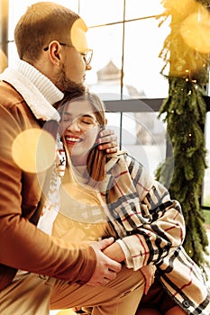 Lovely young couple cuddling at home, adorable woman smiling, enjoy tender moments, festive Christmas mood, New Year