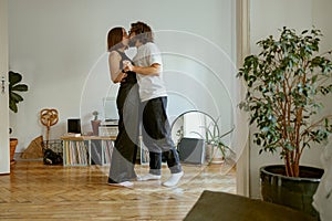 Lovely young couple dancing and kissing together at home. Romantic family time