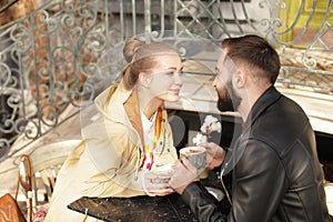 Lovely young couple enjoying tasty coffee at table
