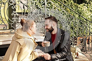 Lovely young couple enjoying tasty coffee at table