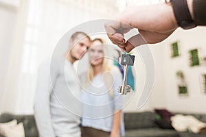 A lovely young couple gets the keys to their new apartment from a real estate agent.
