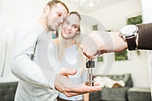 A lovely young couple gets the keys to their new apartment from a real estate agent.