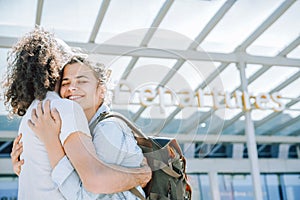 Lovely young couple hugging at the airport departures