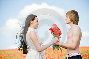 Lovely young couple in the poppy field