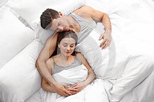 Lovely young couple sleeping in large bed