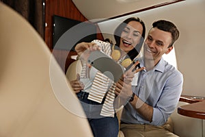 Lovely young couple taking selfie in airplane