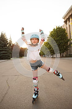 Lovely young girl enjoying rollerblading outdoors