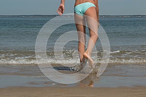 Lovely young girl walking on the sea coast