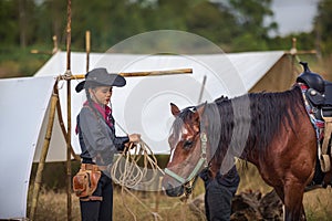 A lovely young lady Cowgirl standing on a ranch with her horse Happy woman cowgirl caring for her horse on the farm