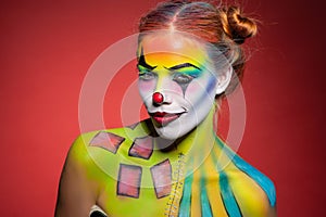Lovely young lady with a face painting clown