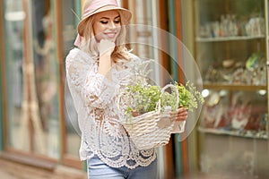 A Lovely young lady in summer hat resting in open-air cafe propped face with hand and waiting friend.