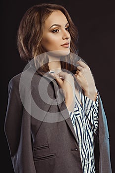 Lovely young model posing in shirt and jacket on her shoulders