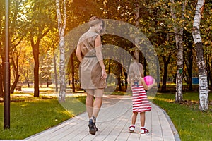 Lovely young mom and daughter in warm sunny summer day. Happy family mother and child little daughter playing and