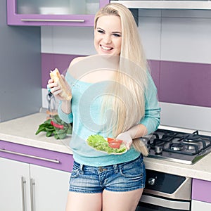 Lovely young pregnant woman enjoying fresh bread and salad